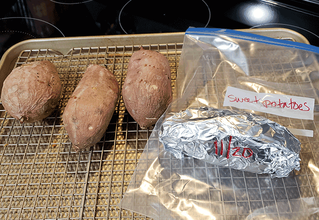 Sweet potatoes baking in the oven with some in foil to store in the freezer. 