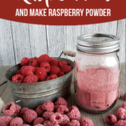 Red rapsberries in a metal dish, powdered dried raspberry in a jar with spoon, and dehydrated raspberries on table.