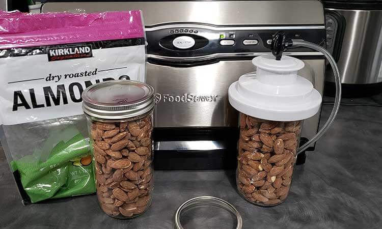 2 mason jars of almonds with a Food Saver for storing nuts