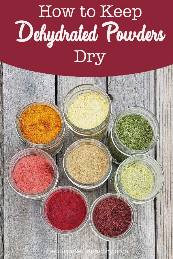 Row of dehydrated vegetable and fruit powders in glass mason jars with silver lids on wooden background