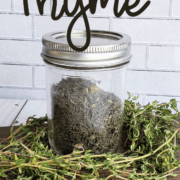 Mason jar of dried time on a bed of fresh thyme for How to Dehydrate Thyme