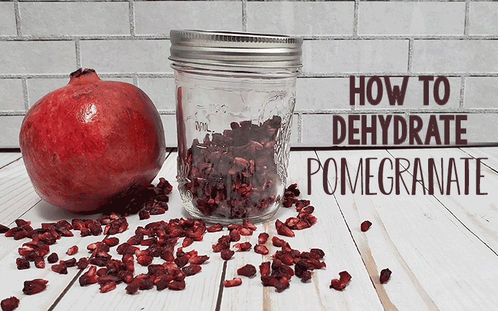 Pomegrate and jar of dehydrated pomegranate arils on white background