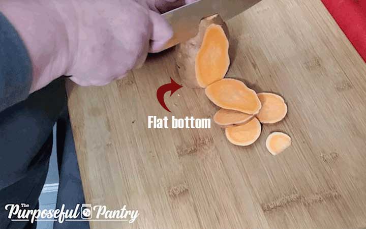Cutting sweet potatoes on a wooden cutting board
