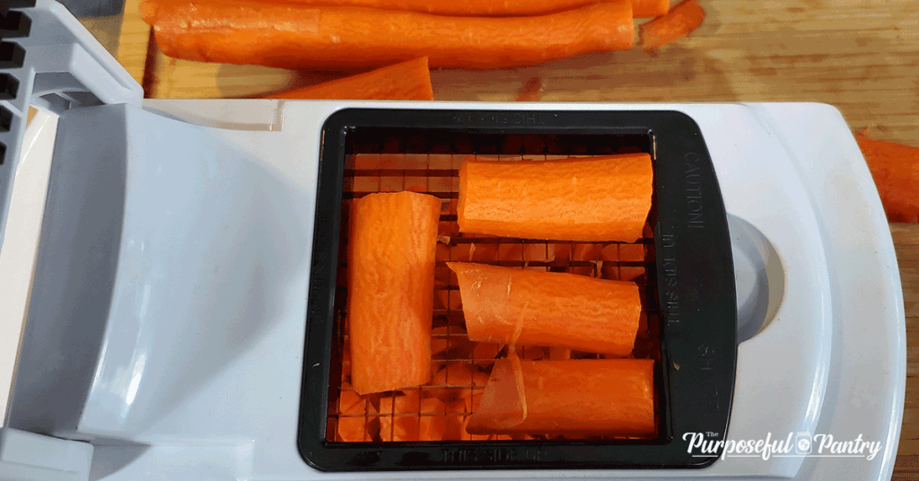 Carrots being iced in a chopper, preparing for dehydrated mirepoix powder