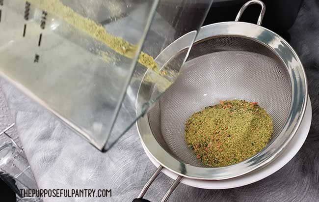 Straining vegetable powder through a fine mesh strainer