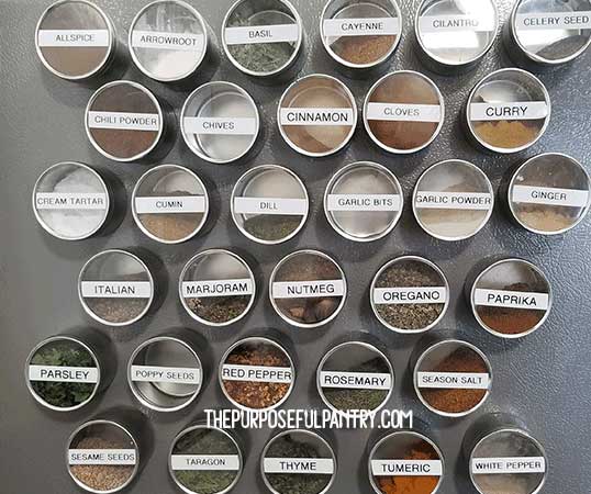 Magnetic spice canisters on the side of a gray referigerator