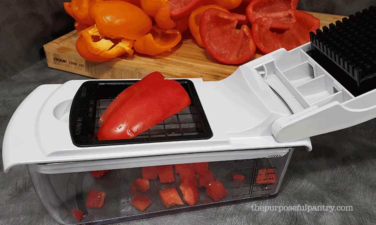 Red bell pepper being diced in a Fullstar Vegetable Chopper