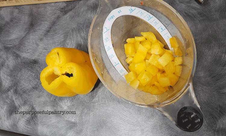 Yellow Bell pepper and diced bell pepper in measuring cup.