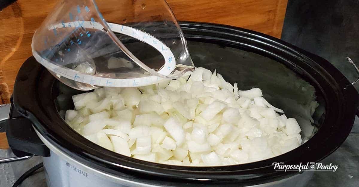 Chopped white onions in a slow cooker to be caramelized