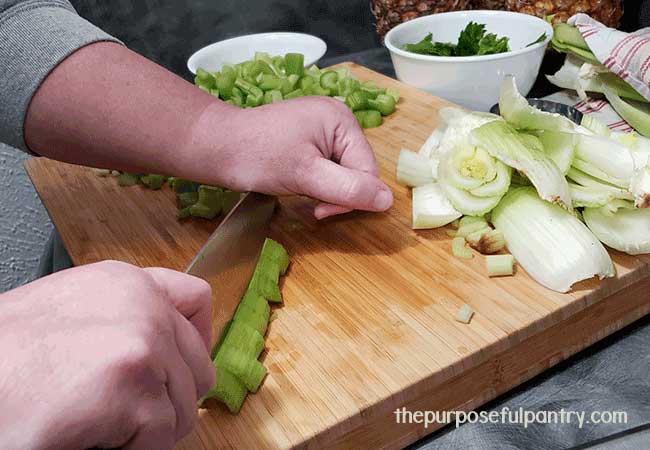 Various parts of celery on a chopping block preparing to dehydrate celery