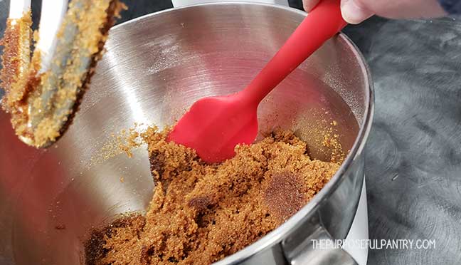 Mixing homemade brown sugar in a Kitchen Aid mixer with a red spatula