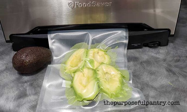 A bag of havlved avocados being vacuum sealed with a Foodsaver Vacuum Sealer