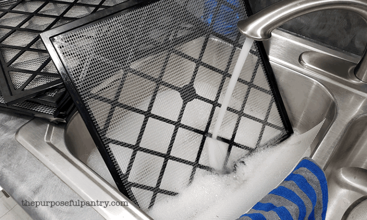 excalibur dehydrator trays in a sink full of suds being cleaned