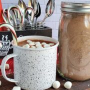 Hot cocoa in a cup with a bulk hot cocoa mix in a mason jar