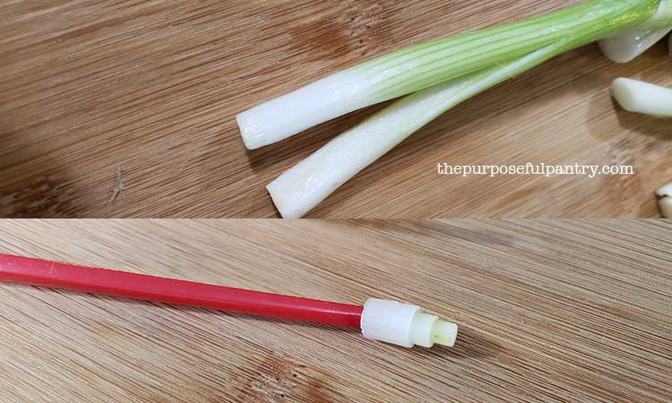 Green onions sliced on a wooden cutting board