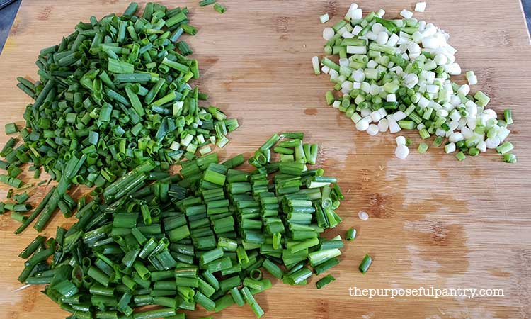 Green onions or scallions chopped on a wooden cutting board