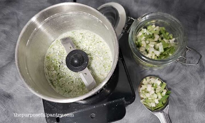 Dehydrated green onions being powdered in a Cuisinart coffee grinder