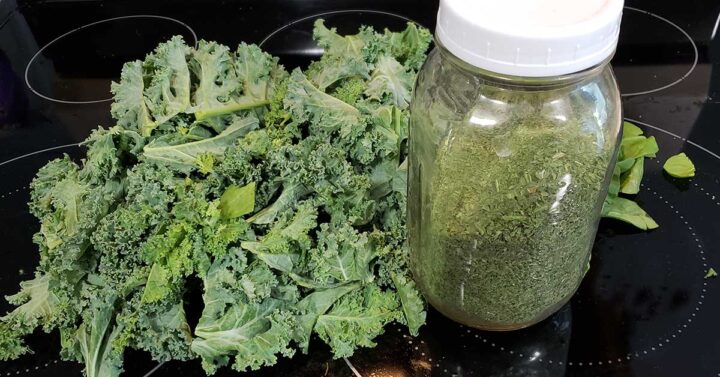 a pile of greens - kale and spinach - and a jar of dehydrated green powder