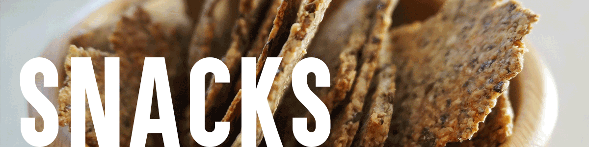 Dehydrated seed crackers in a wooden bowl with text overlay "Snacks"