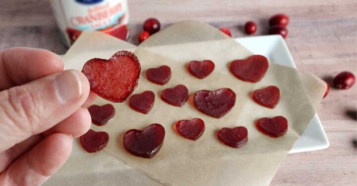 A plate of dried cranberry sauce gummies in a heart shape.