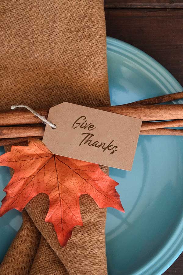 Fall decor on a blue plate with a tag that reads Give Thanks