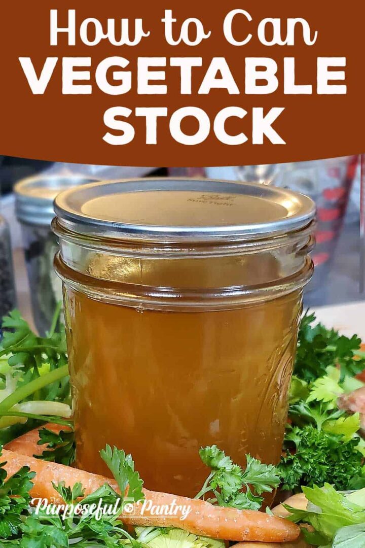 Canned jar of vegetable stock on a bed of fresh vegetables.