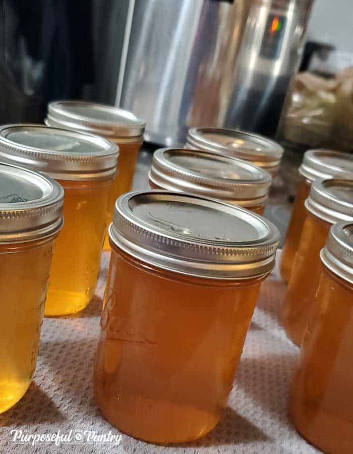 8 jars of canned vegetable stock in front of a Presto pressure canner