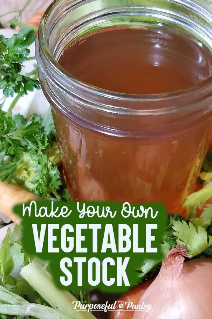 Jar of vegetable broth sitting on a bed of fresh vegetables