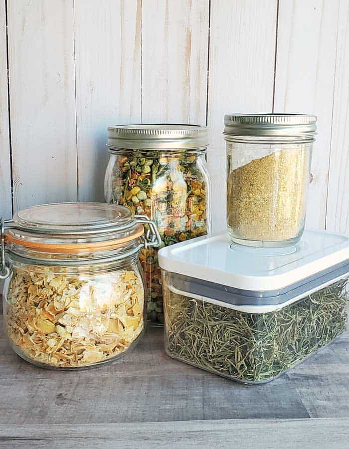 Different containers holding dehydrated foods on a wooden surface