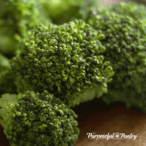 broccoli florets on a wooden cutting board