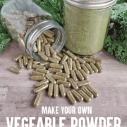 Bottle of vegetable powder capsules spilling in front of jar of dehydrated green powder in front of fresh greens for Pin