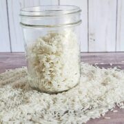 Jar of dehydrated rice on a bed of fresh rice on wooden surfaces