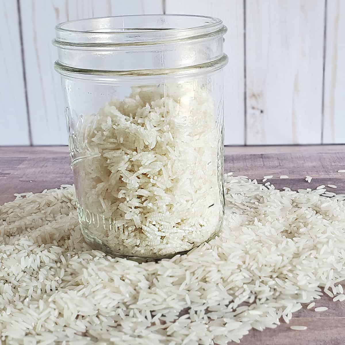 Jar of dehydrated rice on a bed of fresh rice on wooden surfaces