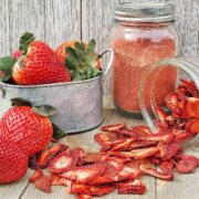 Fresh strawberries, strawberry powder and dried strawberry slices on wooden cutting surfaces