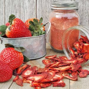 Fresh strawberries, strawberry powder and dried strawberry slices on wooden cutting surfaces