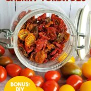 Glass jar of dehydrated tomatoes spilling onto table of fresh cherry and grape tomatoes