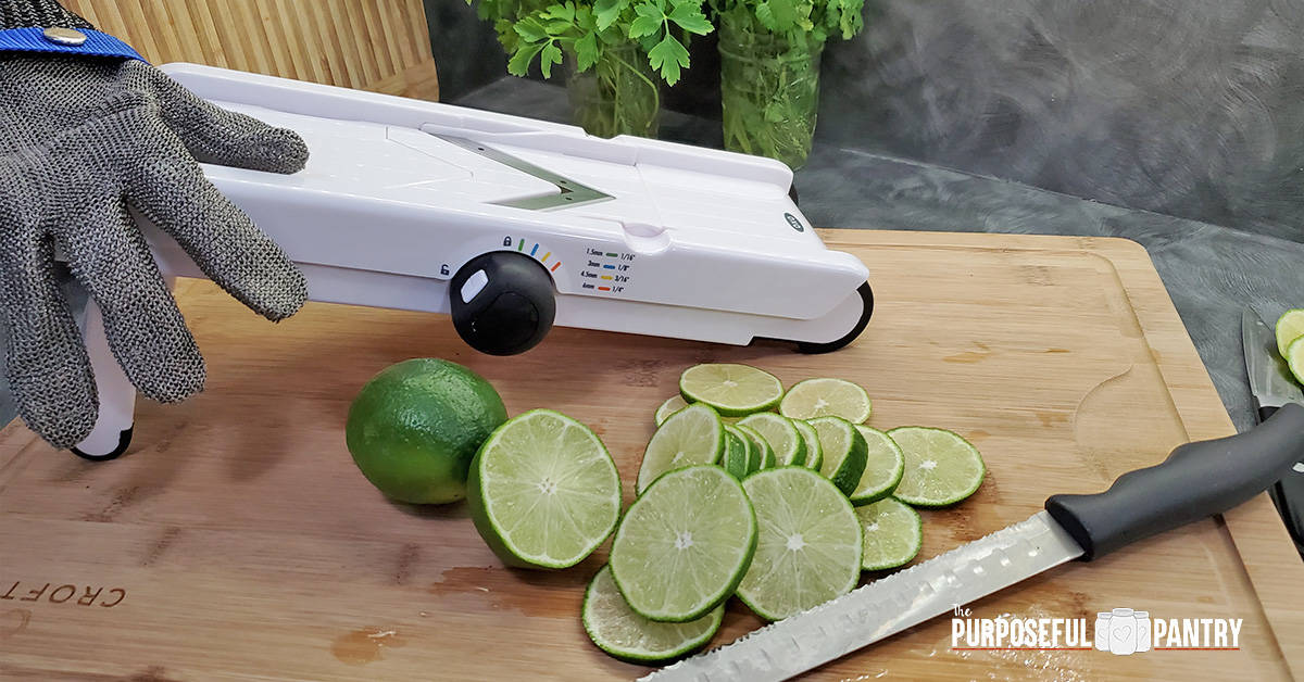 OXO Mandoline with protective glove and sliced lemons on a cutting board