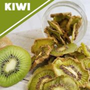 Fresh sliced kiwi with dehydrated kiwi slices falling out of a mason jar onto a white wooden surface