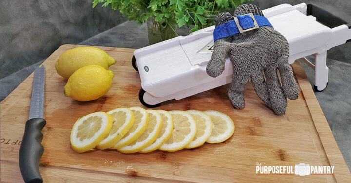 OXO Mandoline with protective glove and sliced lemons on a cutting board