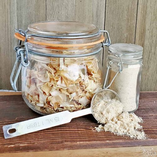 Dehydrated Onions in a clamp glass jar with onion powder in a measuring spoon