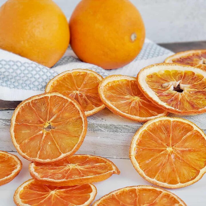 Fresh oranges with sliced dried oranges across the surface