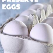 White eggs in a paper white carton on a blue wooden table.