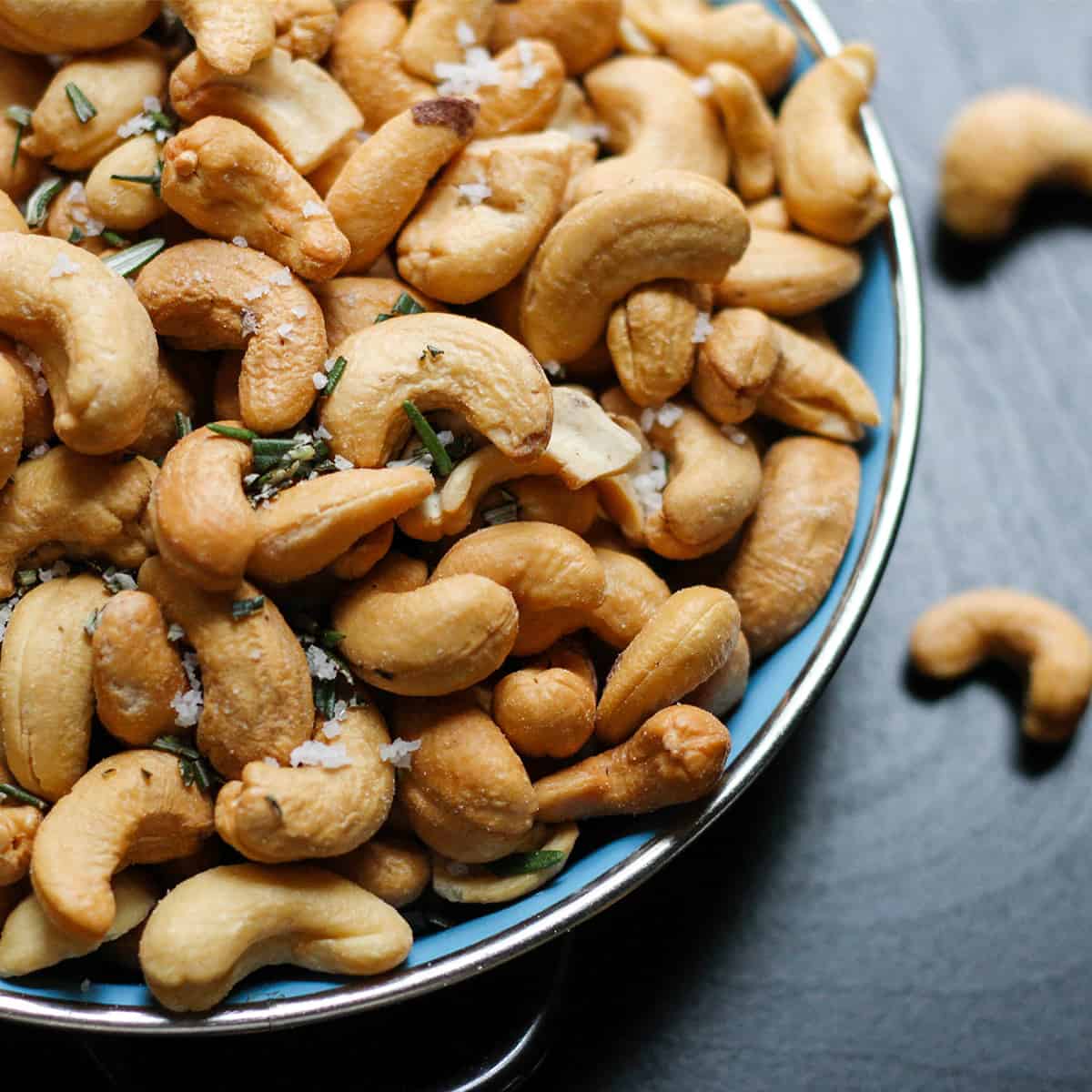 Cashews in a blue bowl on a blue table