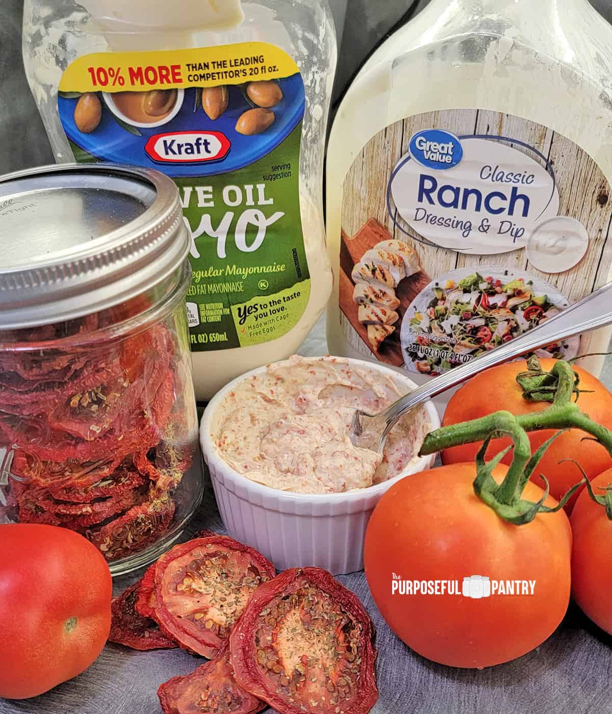Ingredients for Tomato sandwich spread: Mayo bottle, ranch dressing bottle, jar of dried tomatoes, fresh tomatoes