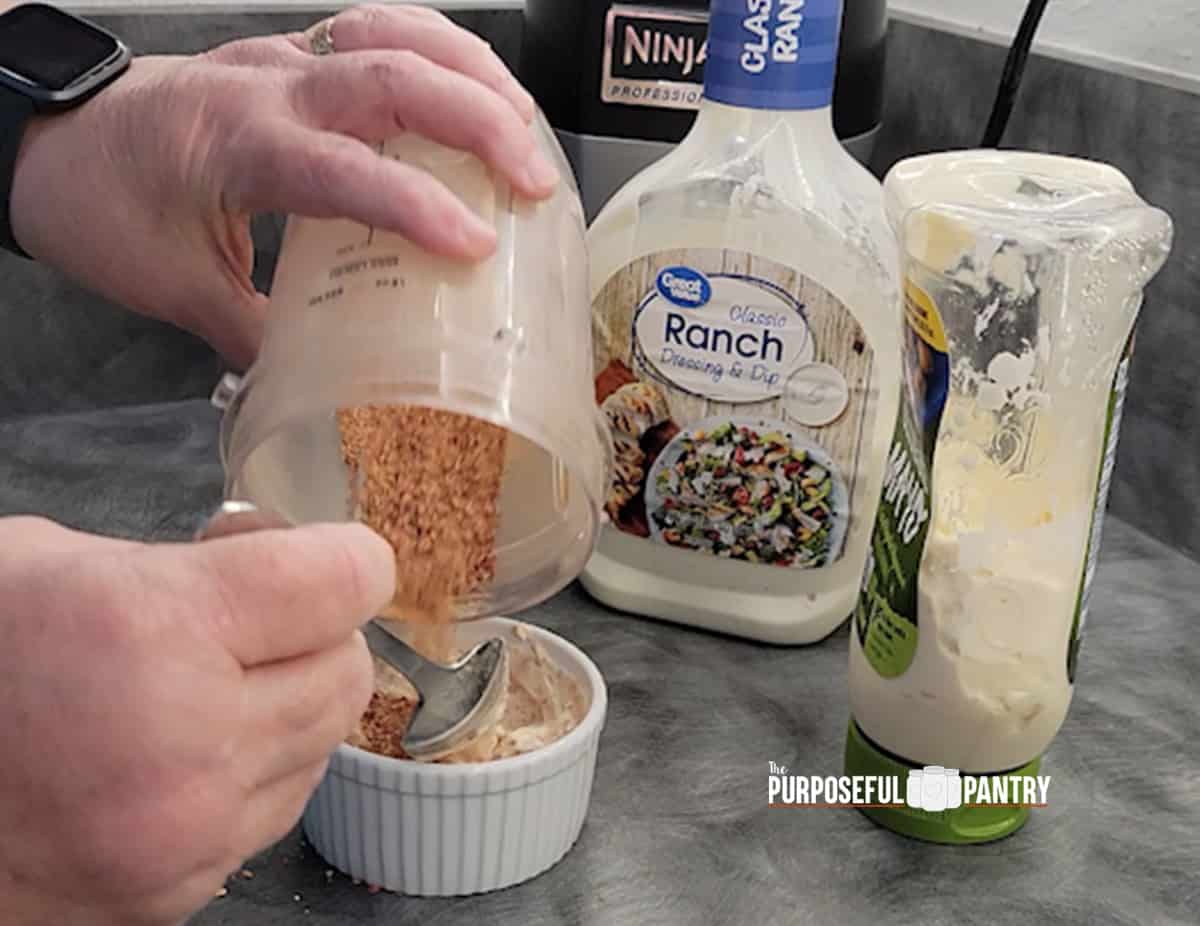 Mayo, Ranch Dressing and tomato powder being mixed for garlic, tomato and herb sandwich spread