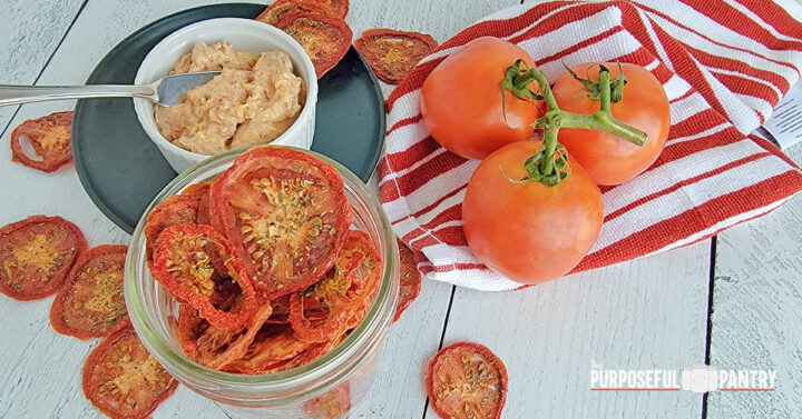 Galicky Tomato Herb sandwich spread with dehydrated tomatoes and fresh tomatoes on a white wooden surface