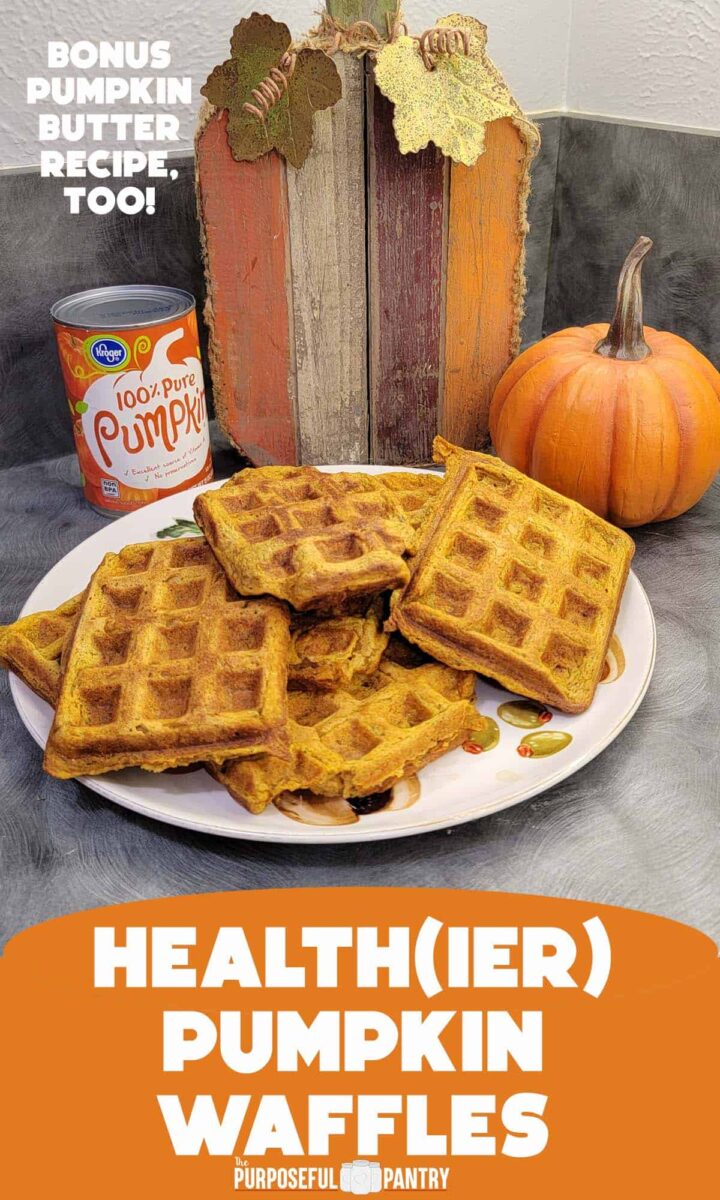 Stack of pumpkin waffles with canned pumpkin puree and some pumpkin decor in the background