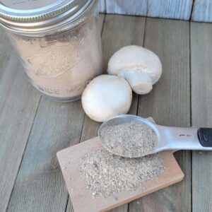 jar of mushroom seasoning blend, mushrooms and blend in a spoon