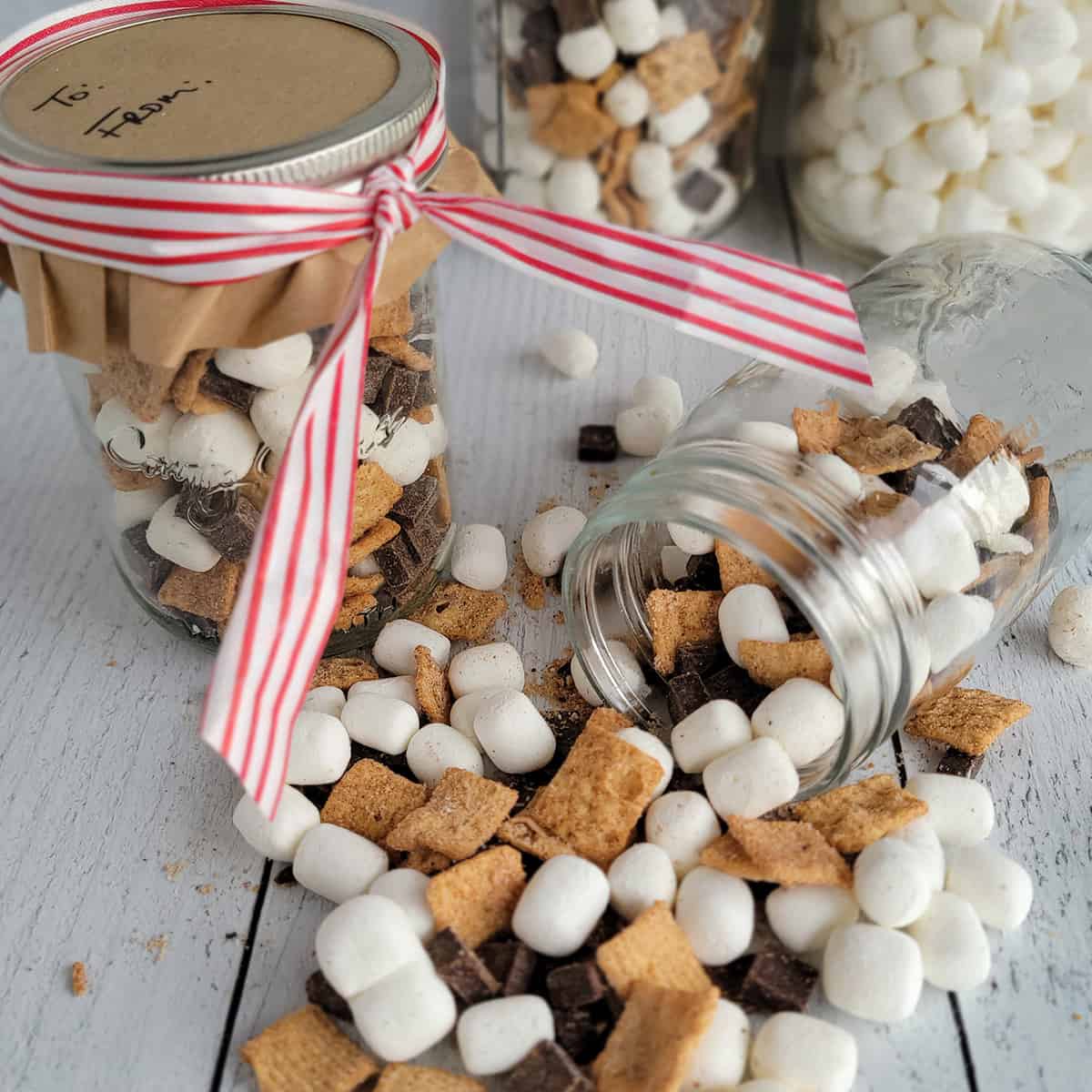 Cruncy S'more Mix in a gift jar and spilled out onto a tabletop.