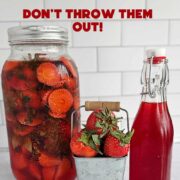 Bottle of strawberry syrup, a stack of strawberries in a metal container, and a jar of strawberry-infused vinegar.